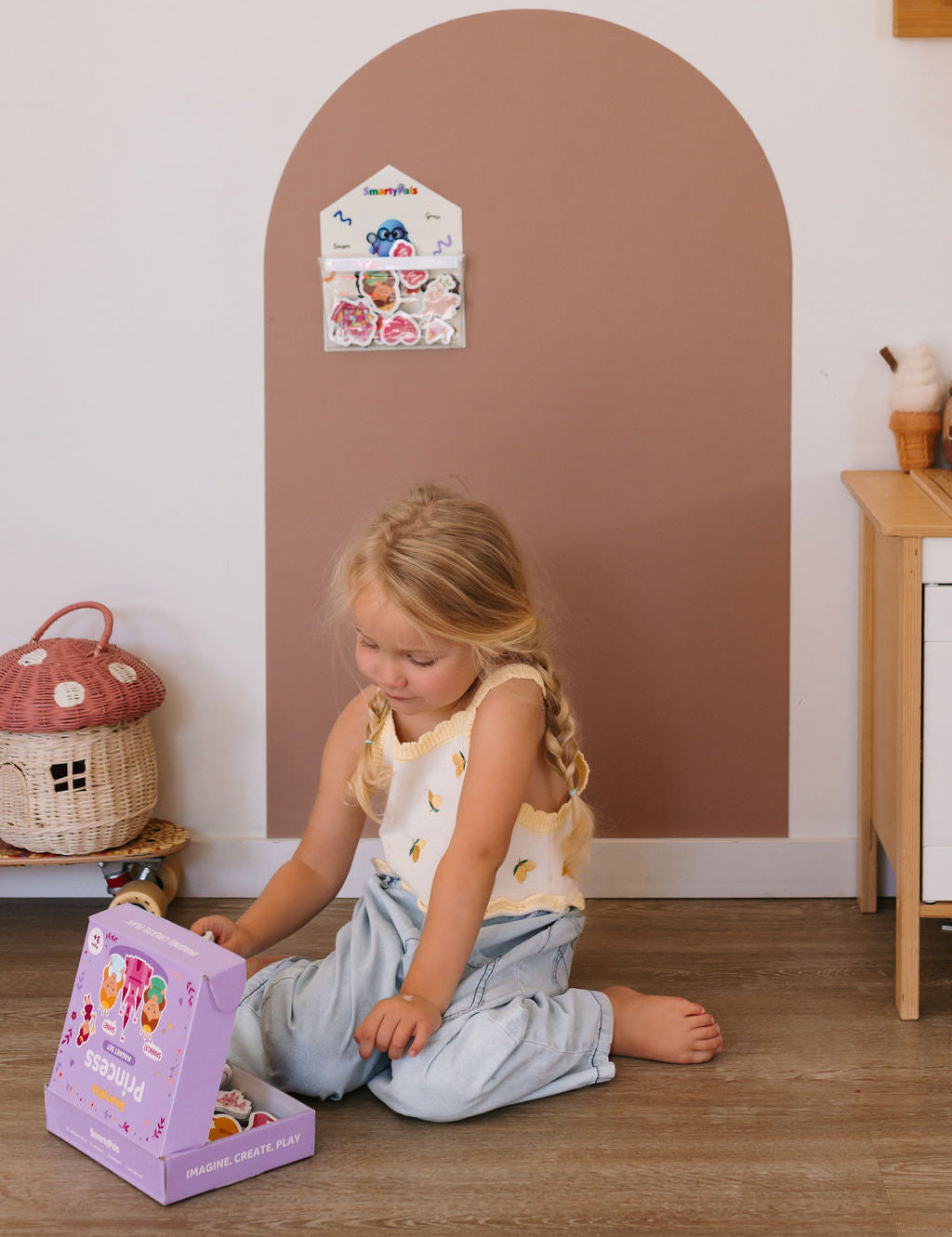 Child building fine motor skills while playing with magnetic shapes on a SmartyPals play wall